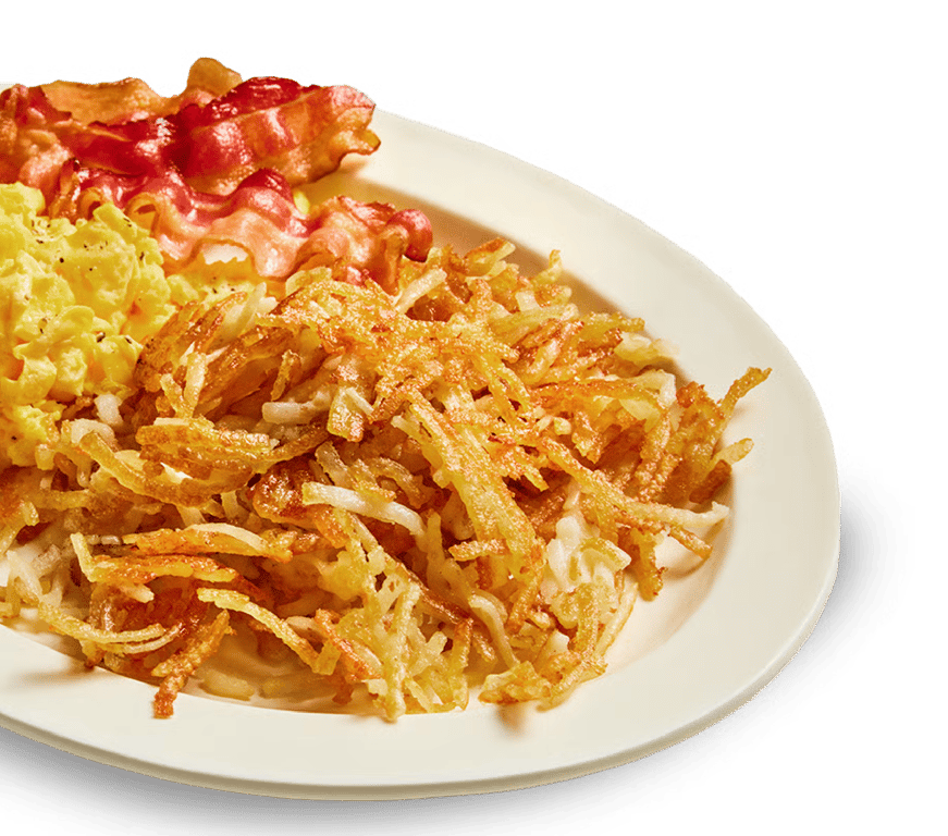 A white plate with crispy hash browns, scrambled eggs, and strips of cooked bacon.
