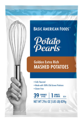 A box of Basic American Foods Potato Pearls® Extra Rich Mashed Potatoes, featuring a hand holding a spatula, product details on the front.