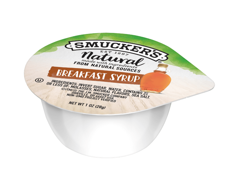 A single-serve Smuckers Natural Breakfast Syrup cup with a white base and a labeled foil lid showing a small syrup bottle and product details.